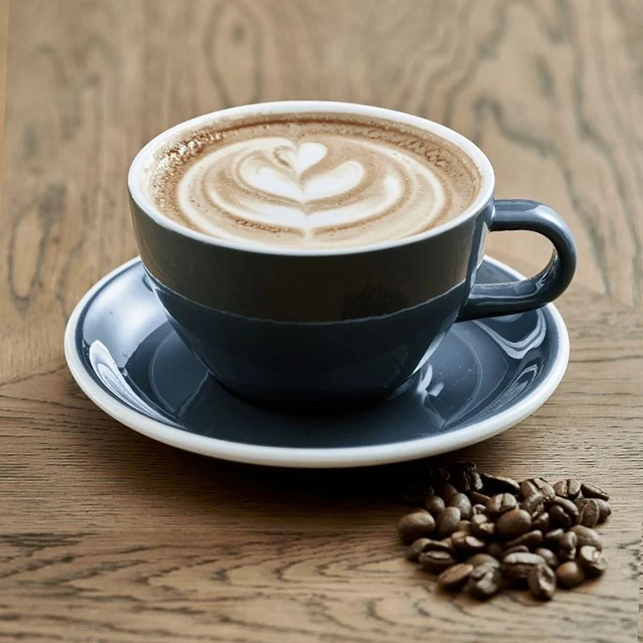 Ahşap masada kalp desenli latte ve kahve çekirdekleri